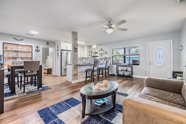 1225 15th St, Palm Harbor, FL 34683 - living area with a ceiling fan, wood finished floors, baseboards, and a textured ceiling