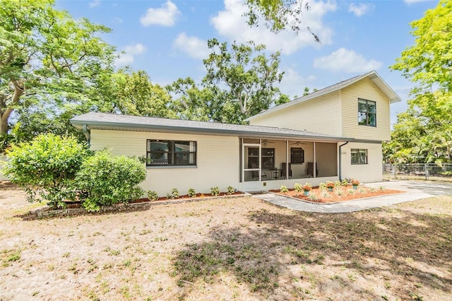 1225 15th St, Palm Harbor, FL 34683 - rear view of house featuring a sunroom, ceiling fan, and fence