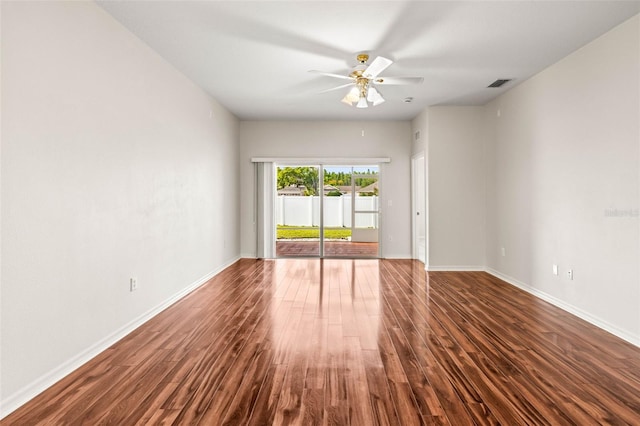 spare room with dark wood finished floors, ceiling fan, and baseboards
