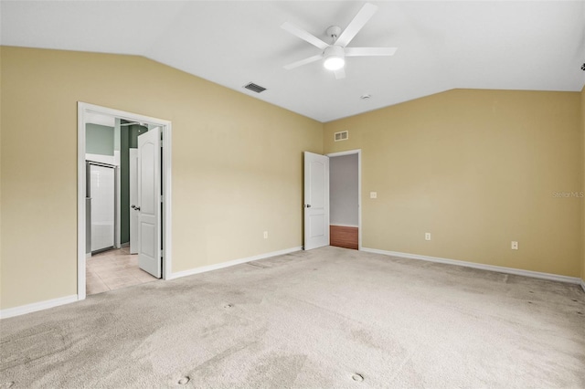 unfurnished bedroom featuring lofted ceiling, light carpet, baseboards, a ceiling fan, and ensuite bathroom