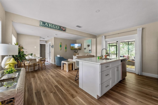 616 11th St NW, Largo, FL 33770 - kitchen featuring a sink, wood finished floors, light countertops, and an island with sink