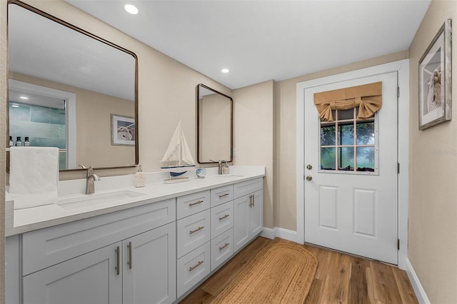 616 11th St NW, Largo, FL 33770 - bathroom with wood finished floors, baseboards, double vanity, and recessed lighting