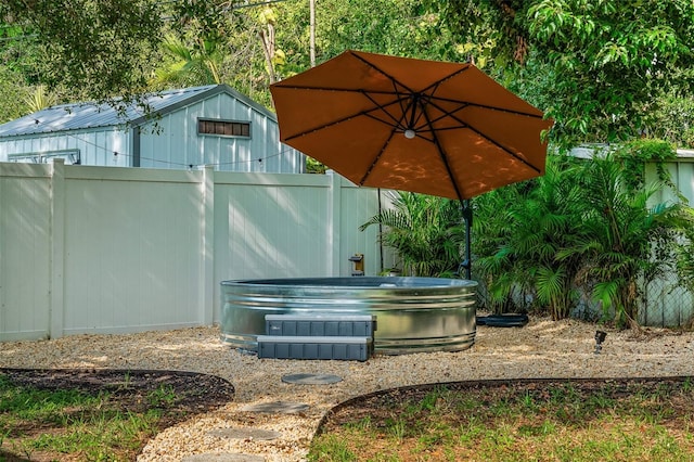 616 11th St NW, Largo, FL 33770 - view of patio / terrace with a hot tub and fence