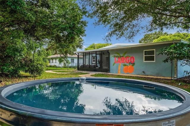 616 11th St NW, Largo, FL 33770 - rear view of house featuring a sunroom and an outdoor pool