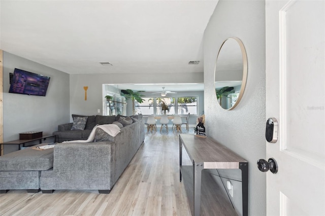 living room with light wood-style flooring and a ceiling fan