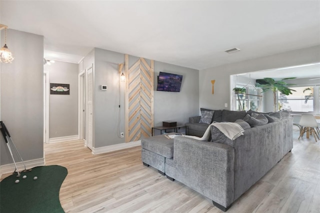living area with light wood-style flooring and baseboards