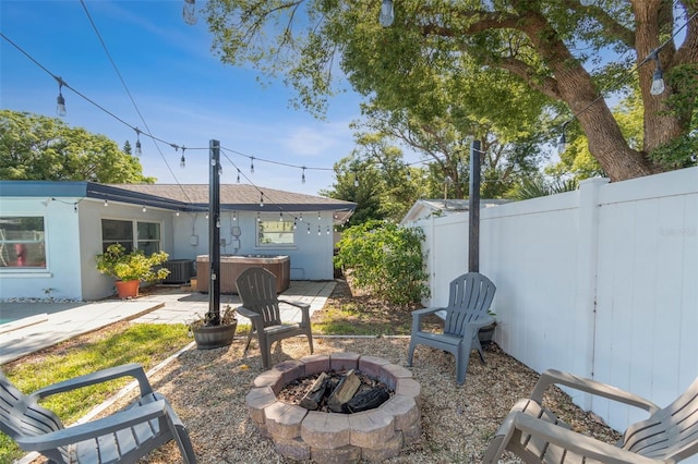 view of yard with an outdoor fire pit, a patio, fence, and cooling unit