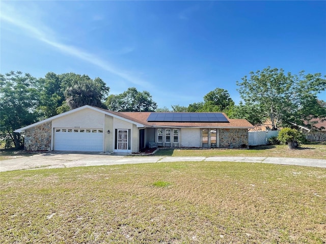 8209 Chaucer Dr, Weeki Wachee, FL 34607 - view of front of property with roof mounted solar panels, concrete driveway, and a garage