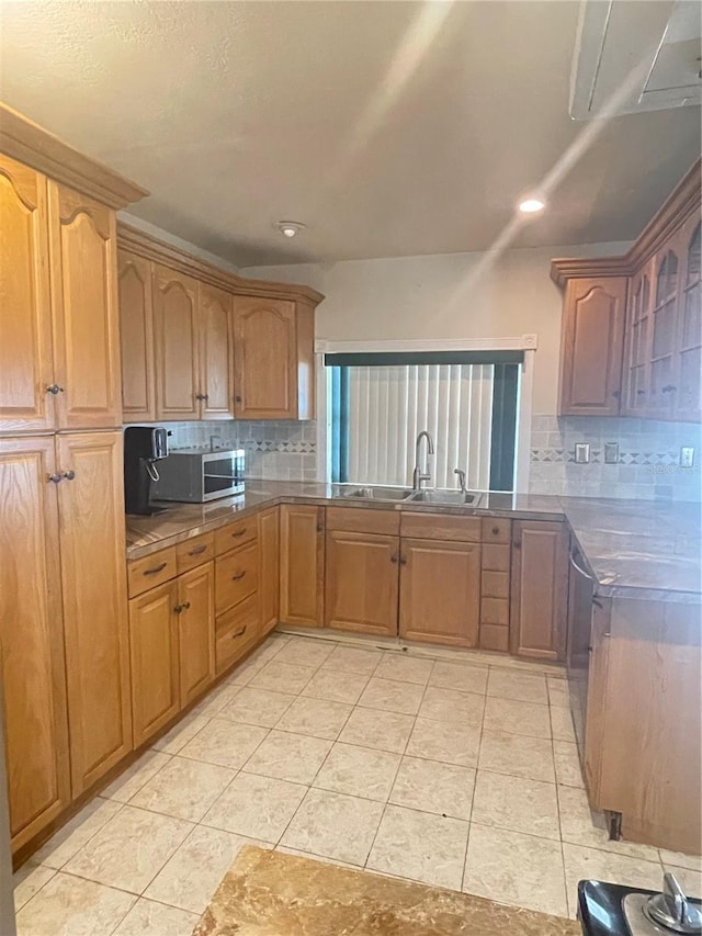 8209 Chaucer Dr, Weeki Wachee, FL 34607 - kitchen featuring stainless steel microwave, backsplash, recessed lighting, dark countertops, and brown cabinetry