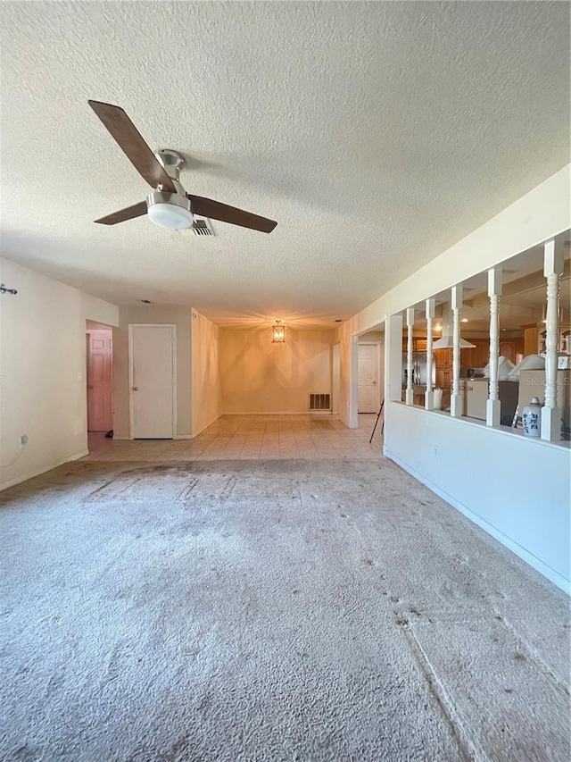 8209 Chaucer Dr, Weeki Wachee, FL 34607 - spare room with a ceiling fan, a textured ceiling, and light colored carpet