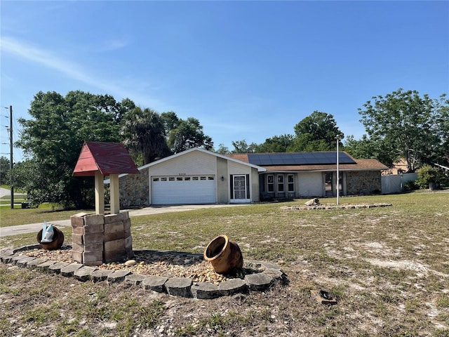 8209 Chaucer Dr, Weeki Wachee, FL 34607 - view of front facade featuring solar panels, a front yard, an attached garage, and driveway