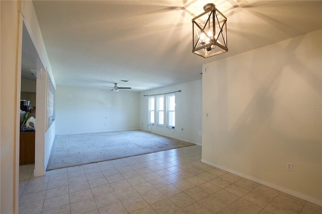8209 Chaucer Dr, Weeki Wachee, FL 34607 - spare room featuring light carpet, a chandelier, light tile patterned floors, and a ceiling fan