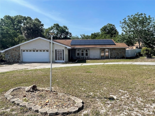 8209 Chaucer Dr, Weeki Wachee, FL 34607 - view of front facade with concrete driveway, solar panels, and a garage
