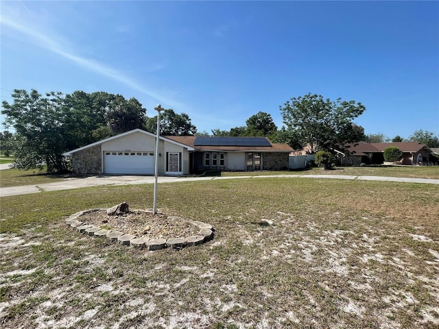 8209 Chaucer Dr, Weeki Wachee, FL 34607 - single story home featuring roof mounted solar panels, driveway, a front yard, and an attached garage