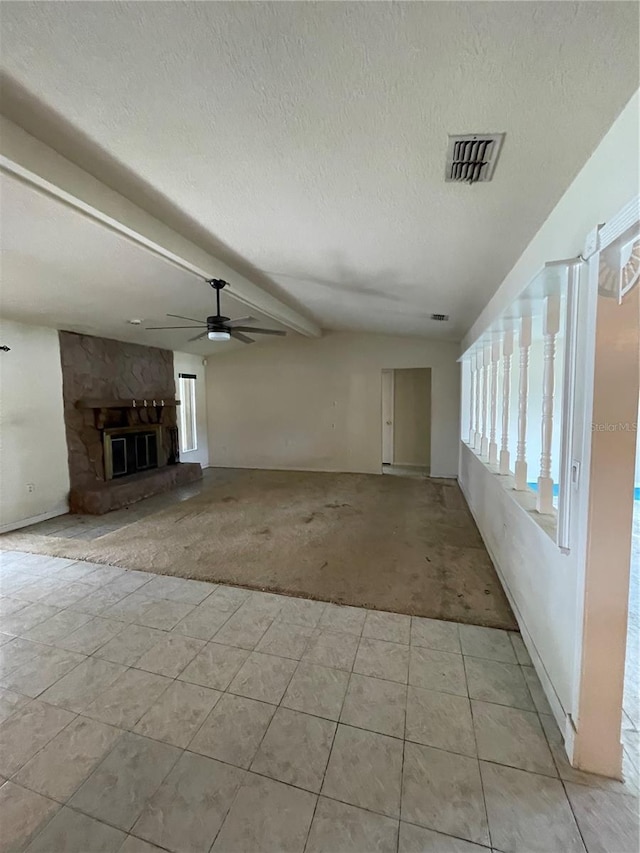 8209 Chaucer Dr, Weeki Wachee, FL 34607 - unfurnished living room featuring light colored carpet, a ceiling fan, a textured ceiling, a stone fireplace, and light tile patterned flooring