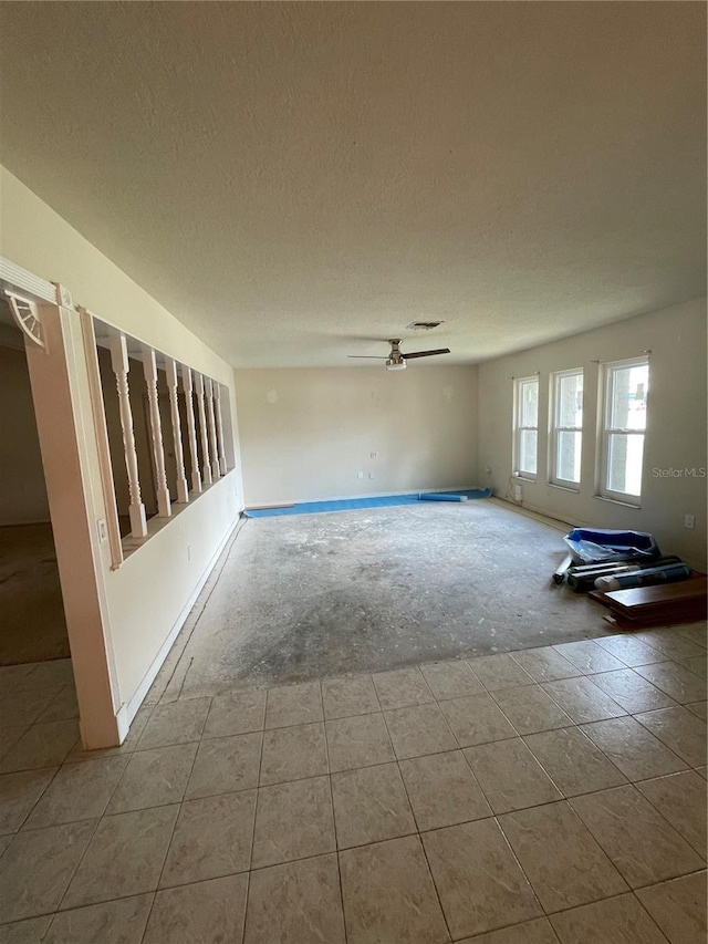 8209 Chaucer Dr, Weeki Wachee, FL 34607 - tiled empty room featuring ceiling fan and a textured ceiling