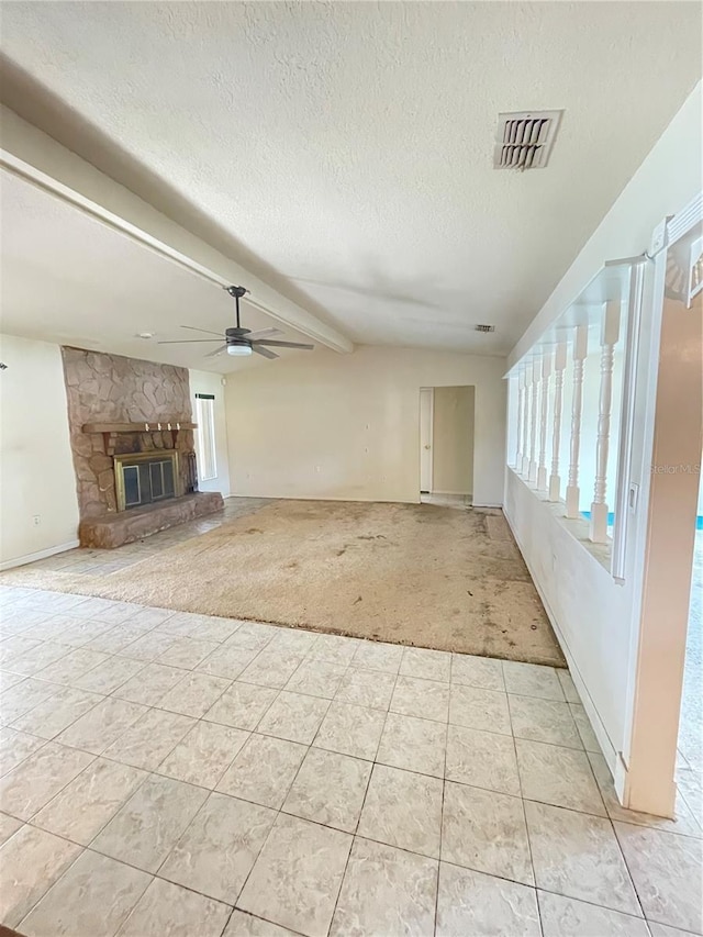 8209 Chaucer Dr, Weeki Wachee, FL 34607 - unfurnished living room featuring light carpet, ceiling fan, a textured ceiling, a fireplace, and light tile patterned flooring