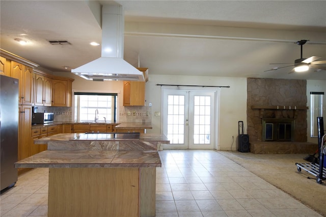 8209 Chaucer Dr, Weeki Wachee, FL 34607 - kitchen with island exhaust hood, open floor plan, stainless steel appliances, a center island, and backsplash