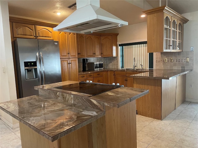 8209 Chaucer Dr, Weeki Wachee, FL 34607 - kitchen with island exhaust hood, stainless steel appliances, dark countertops, a peninsula, and glass insert cabinets