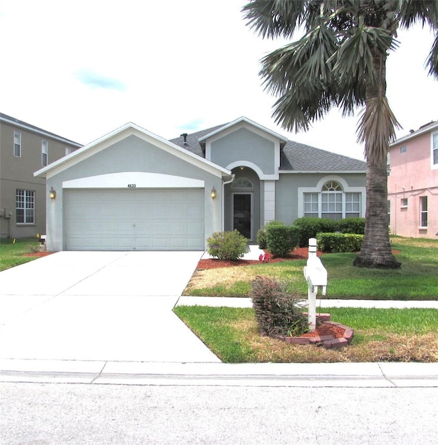 ranch-style house featuring stucco siding, an attached garage, driveway, and a front yard