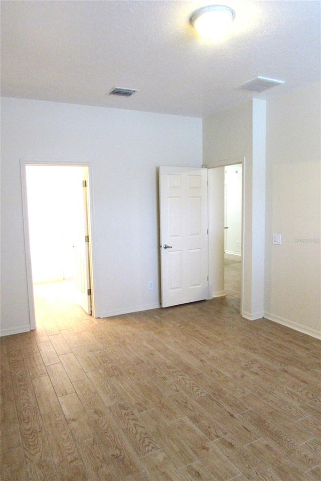 spare room with light wood finished floors and baseboards