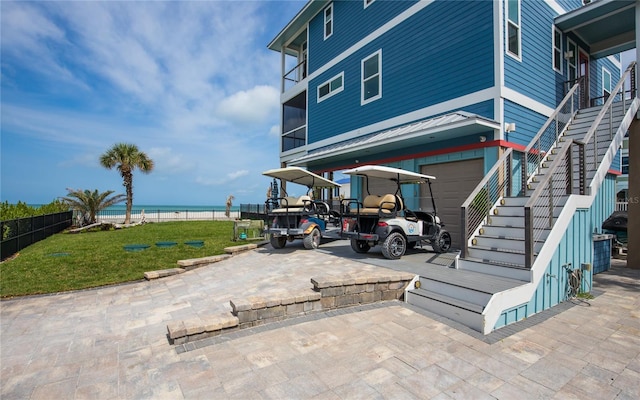 4620 Oro Pesos Ln, Captiva, FL 33924 - view of patio with stairs, an attached garage, a water view, and driveway