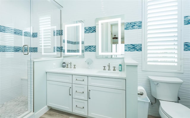 4620 Oro Pesos Ln, Captiva, FL 33924 - bathroom with a stall shower, double vanity, toilet, and tile walls
