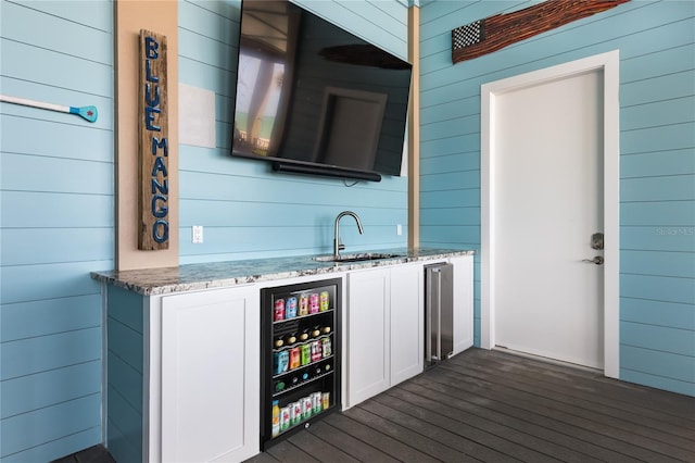 4620 Oro Pesos Ln, Captiva, FL 33924 - indoor wet bar featuring wood walls and dark wood-style flooring