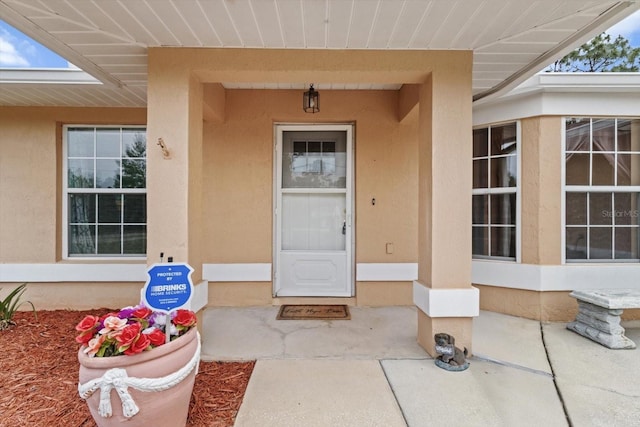 view of exterior entry with stucco siding