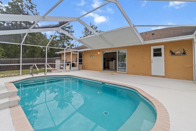view of pool with fence, a patio area, and a lanai