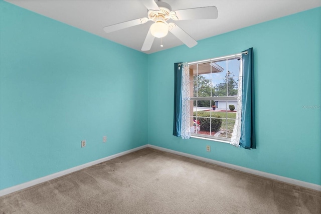 carpeted empty room featuring baseboards and ceiling fan
