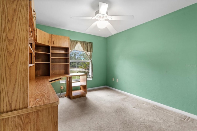 unfurnished office with carpet flooring, ceiling fan, and baseboards