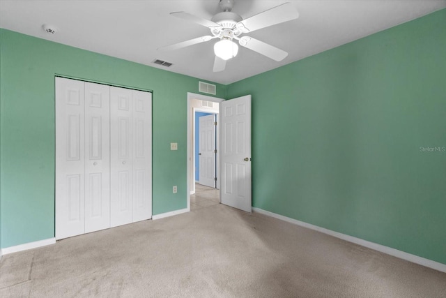 unfurnished bedroom featuring light carpet, a closet, baseboards, and a ceiling fan