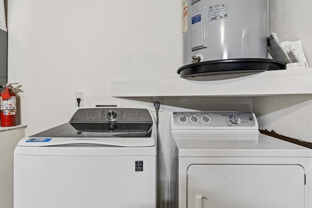 clothes washing area featuring separate washer and dryer and electric water heater