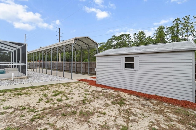 view of yard featuring fence, an outdoor structure, and a lanai