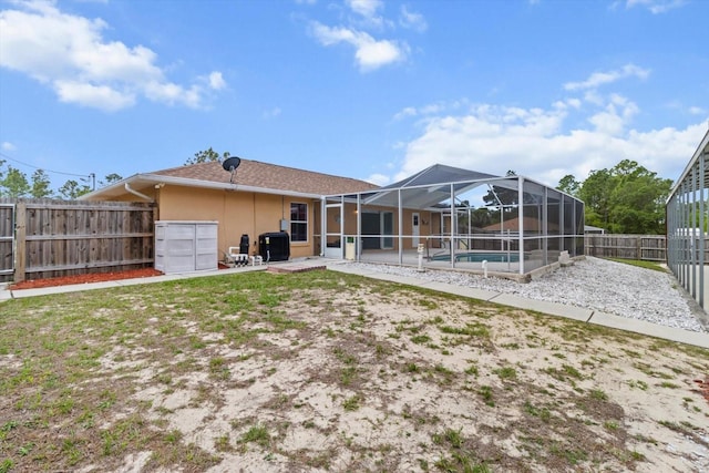 rear view of house with a fenced backyard, a patio, a lanai, and stucco siding