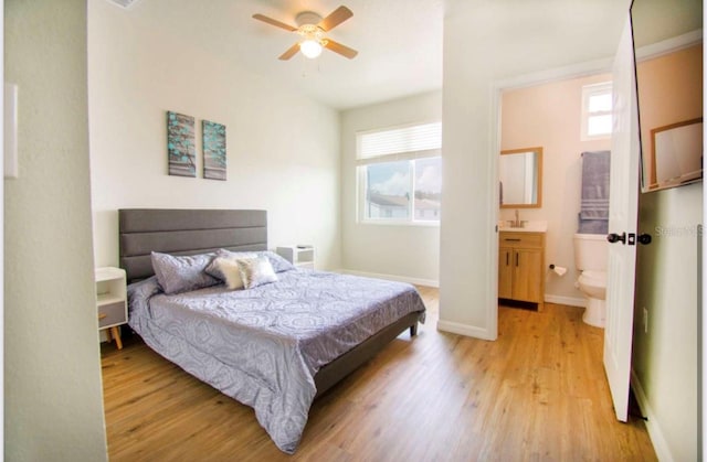 1933 Oxnard Ct, Tampa, FL 33612 - bedroom with light wood finished floors, multiple windows, baseboards, and ensuite bathroom