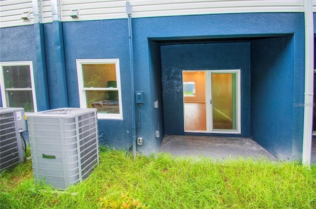 1933 Oxnard Ct, Tampa, FL 33612 - doorway to property featuring cooling unit and stucco siding