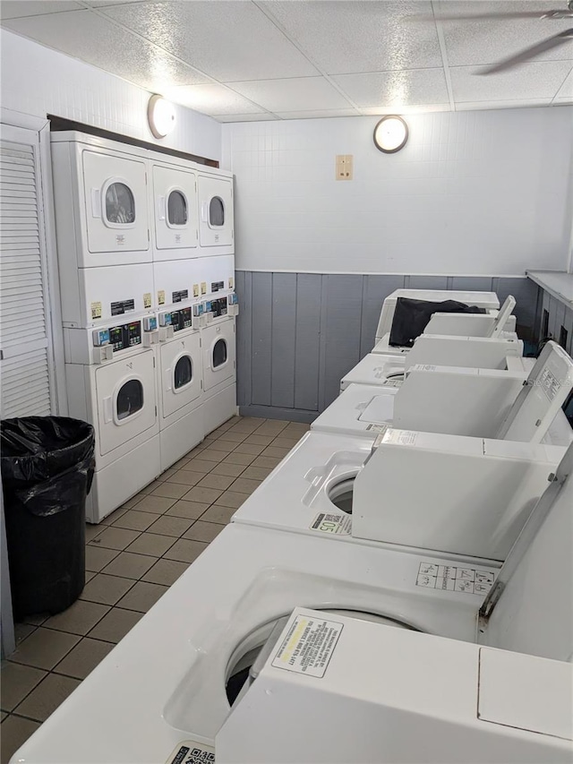 3840 N Lake Dr Unit 125, Tampa, FL 33614 - shared laundry with estacked washer and dryer, washing machine and dryer, wood walls, and tile patterned flooring