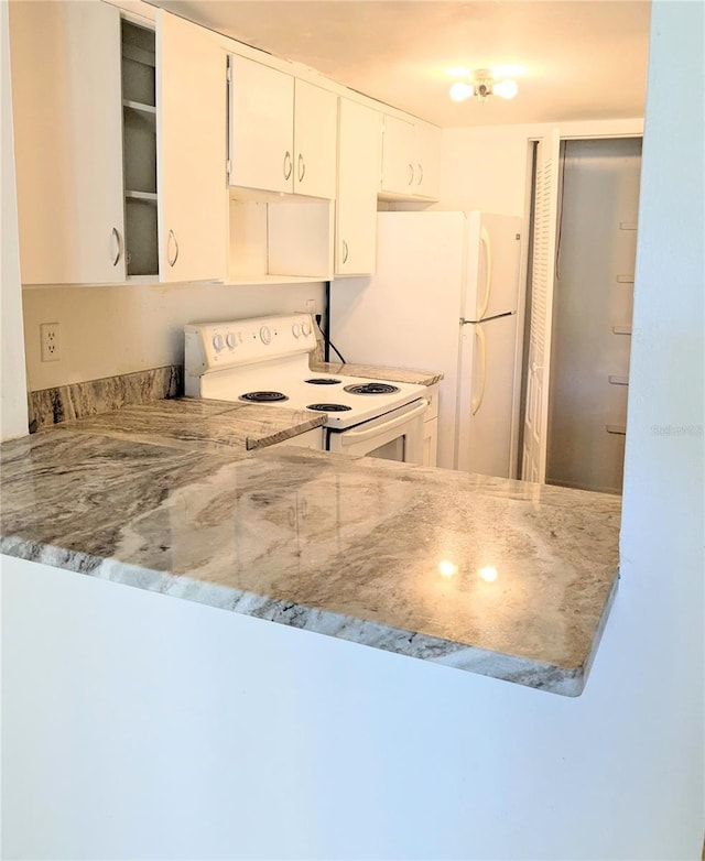 3840 N Lake Dr Unit 125, Tampa, FL 33614 - kitchen with white appliances, white cabinets, and a peninsula