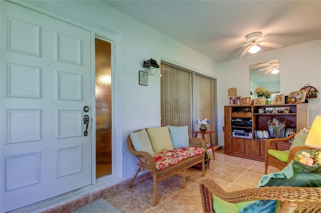 living area with ceiling fan and light tile patterned flooring
