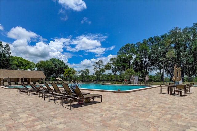 community pool featuring fence and a patio area