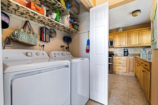 laundry area with washing machine and clothes dryer and light tile patterned flooring