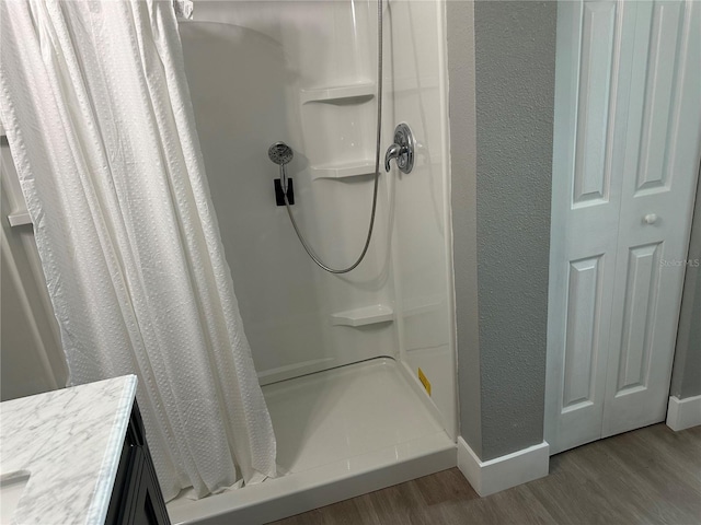 11729 John Robbins Rd, Riverview, FL 33578 - bathroom featuring wood finished floors, a stall shower, baseboards, and a textured wall