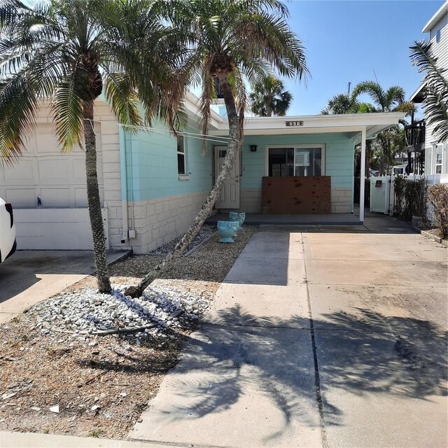 319 Boca Ciega Dr, Madeira Beach, FL 33708 - view of front of home featuring concrete driveway and an attached garage