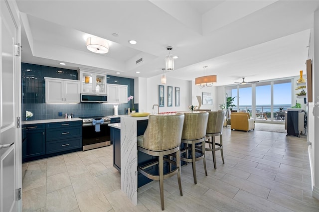 1325 Snell Isle Blvd NE Unit 810, Saint Petersburg, FL 33704 - kitchen with appliances with stainless steel finishes, light countertops, white cabinetry, a kitchen breakfast bar, and tasteful backsplash