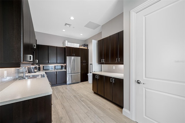 1325 Snell Isle Blvd NE Unit 810, Saint Petersburg, FL 33704 - kitchen with stainless steel appliances, a sink, decorative backsplash, light countertops, and light wood-style floors