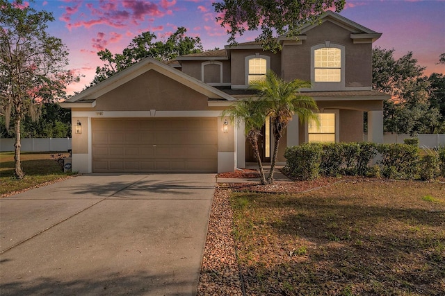 view of front facade featuring stucco siding, concrete driveway, and a garage