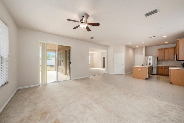 unfurnished living room with ceiling fan, baseboards, recessed lighting, and light colored carpet