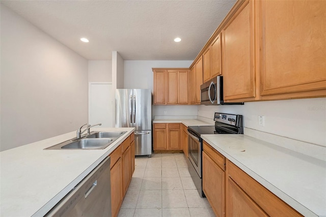 kitchen with appliances with stainless steel finishes, a sink, recessed lighting, light countertops, and light tile patterned floors